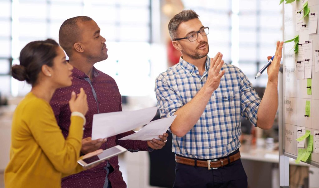 Three team members problem-solving together